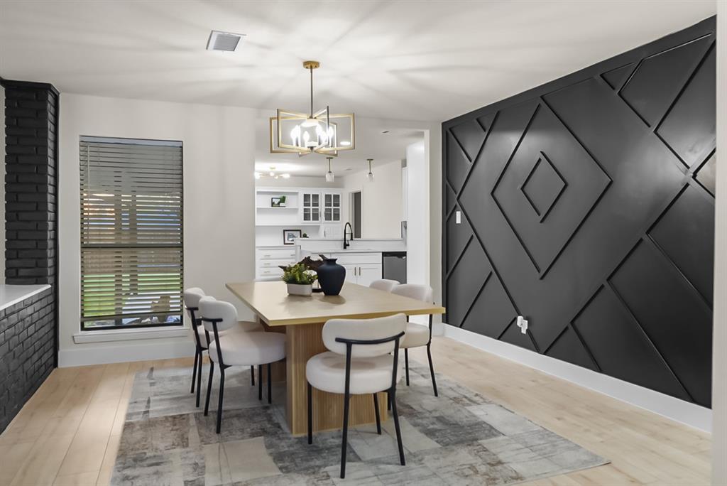 13103 Halwin Circle Dallas, TX 75243 - Photo 2 of 15 Dining space featuring light wood-type flooring, an accent wall, and a chandelier