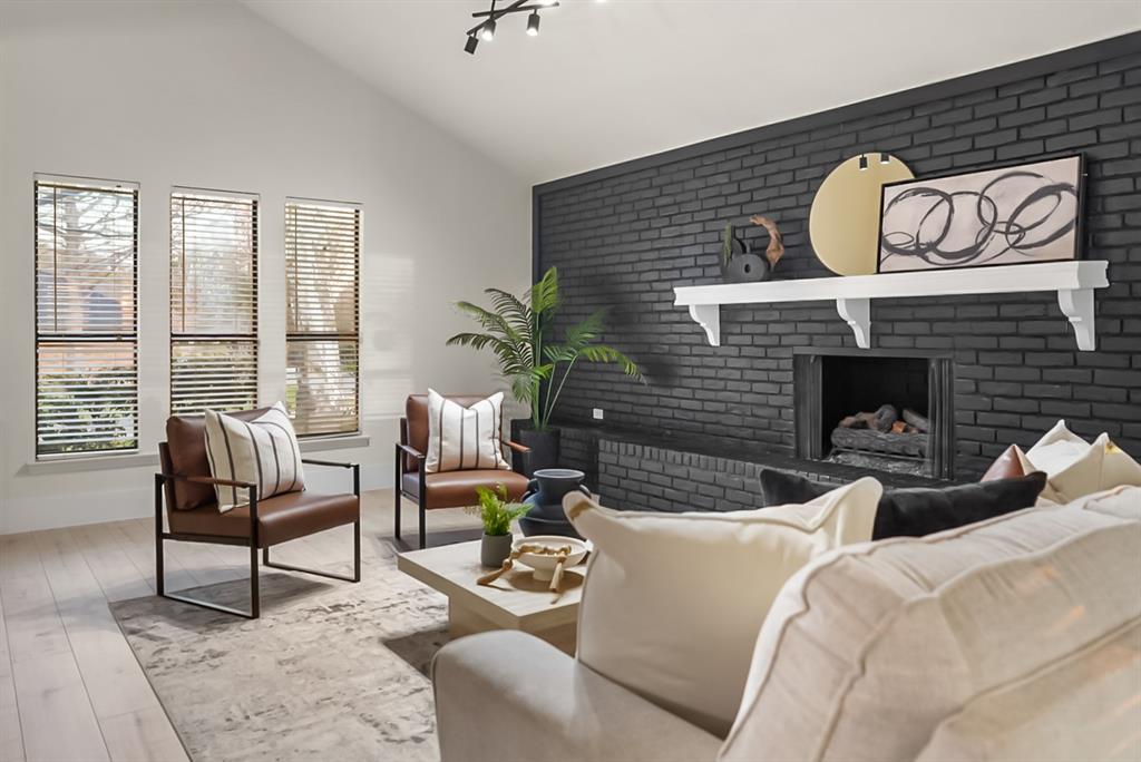 13103 Halwin Circle Dallas, TX 75243 - Photo 4 of 15 Living room featuring light wood-style floors, a brick fireplace, and vaulted ceiling