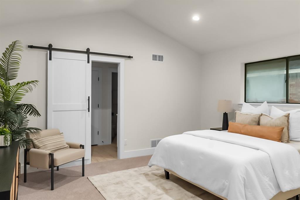 13103 Halwin Circle Dallas, TX 75243 - Photo 8 of 15 Bedroom with a barn door, light carpet, and recessed lighting