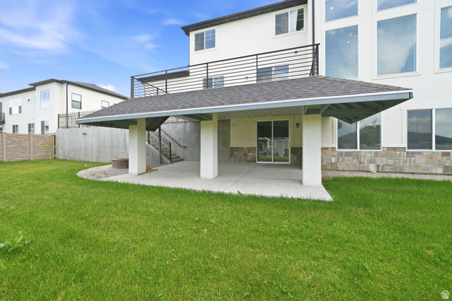1002 West Temple Rim Lane Payson, UT 84651 - Photo 58 of 68 Expansive green lawn with a covered patio featuring square columns and a sliding glass door entry