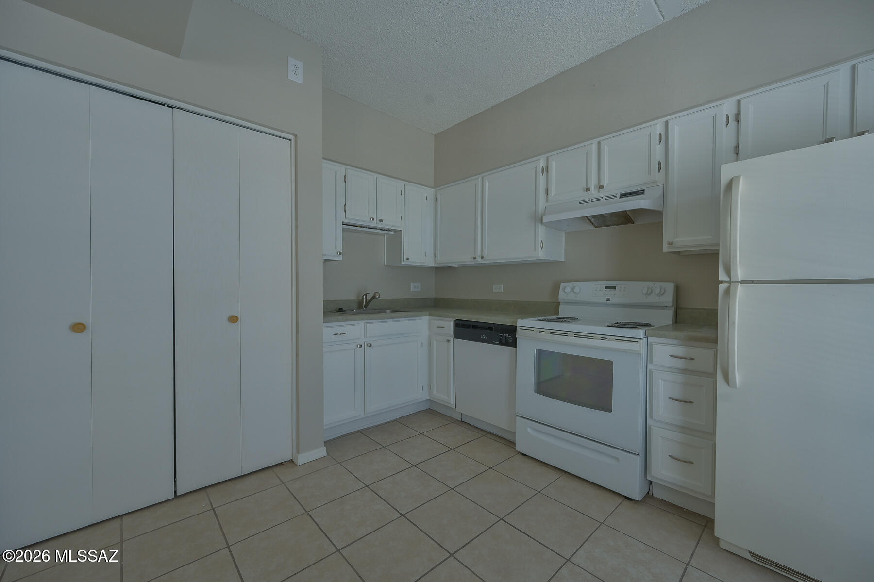 7777 East Golf Links Road, Unit 2308 Tucson, AZ 85730 - Photo 17 of 37 a kitchen with white cabinets and white appliances