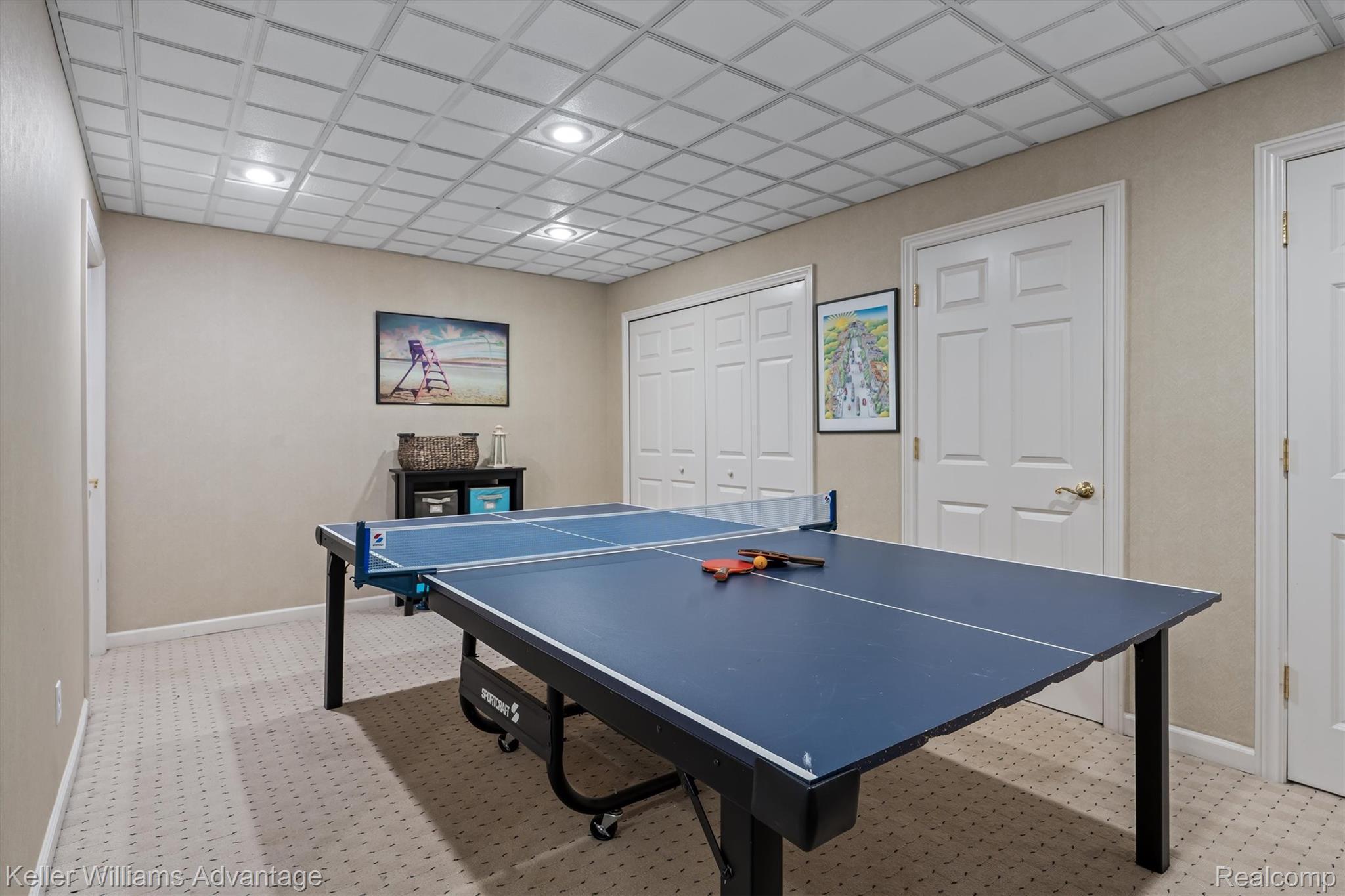 22878 Tree Top Court South Lyon, MI 48178 - Photo 38 of 75 Recessed lighting illuminates a spacious room featuring a grid-patterned ceiling, light-toned walls, and patterned carpet flooring