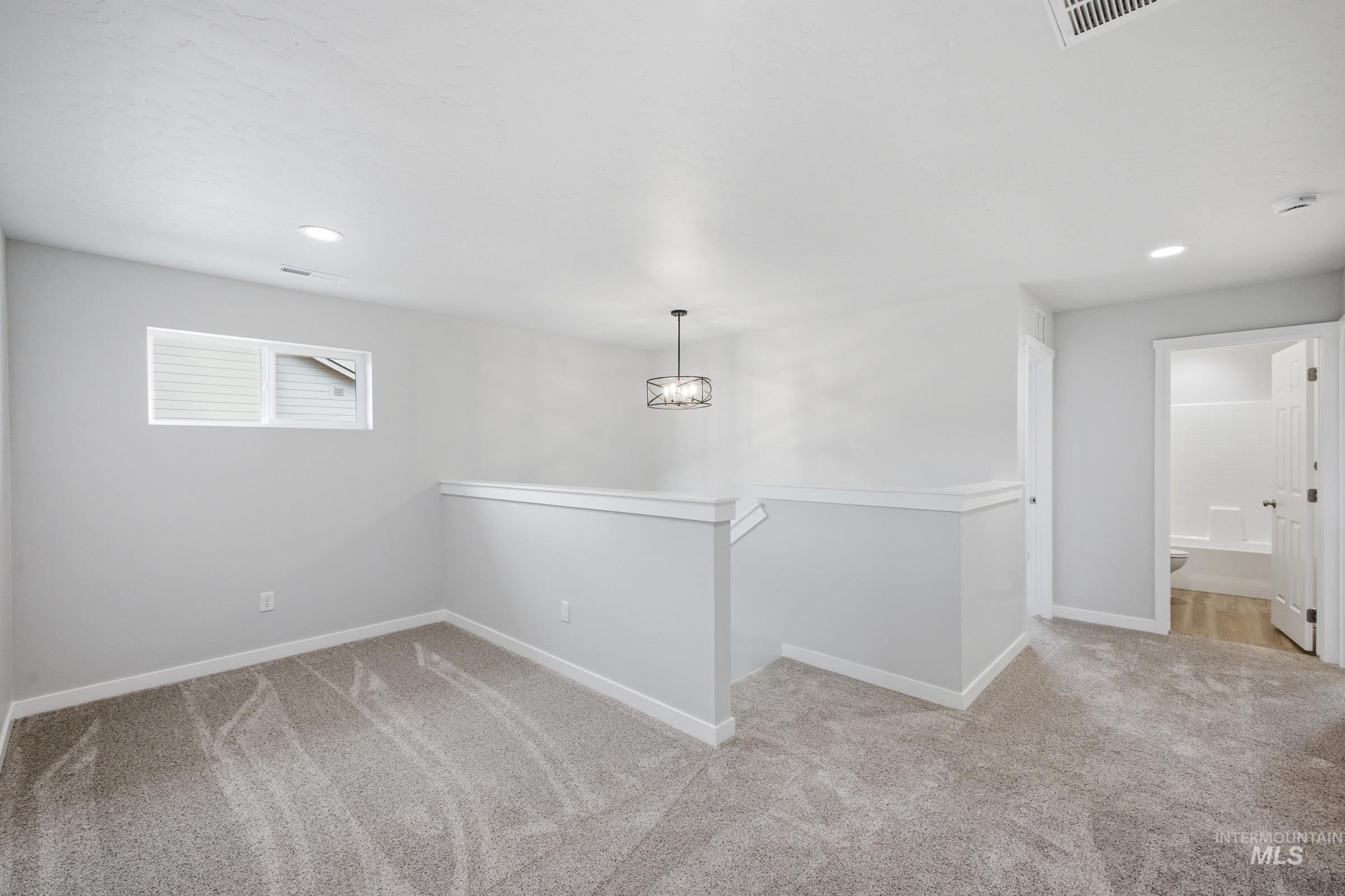 13702 Inman Court Caldwell, ID 83607 - Photo 14 of 23 Corridor with light colored carpet and recessed lighting