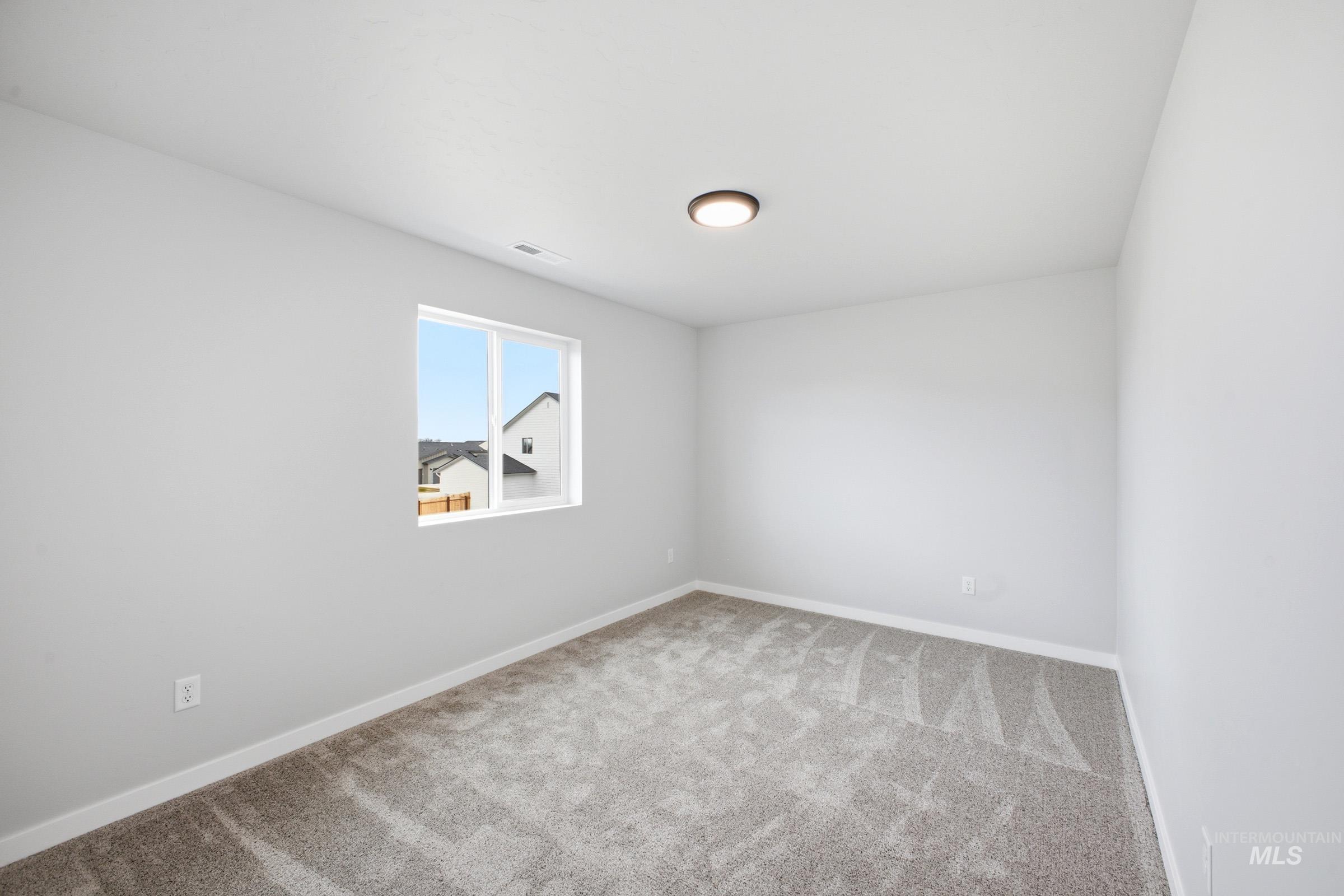 13702 Inman Court Caldwell, ID 83607 - Photo 15 of 23 Spare room featuring light carpet and baseboards