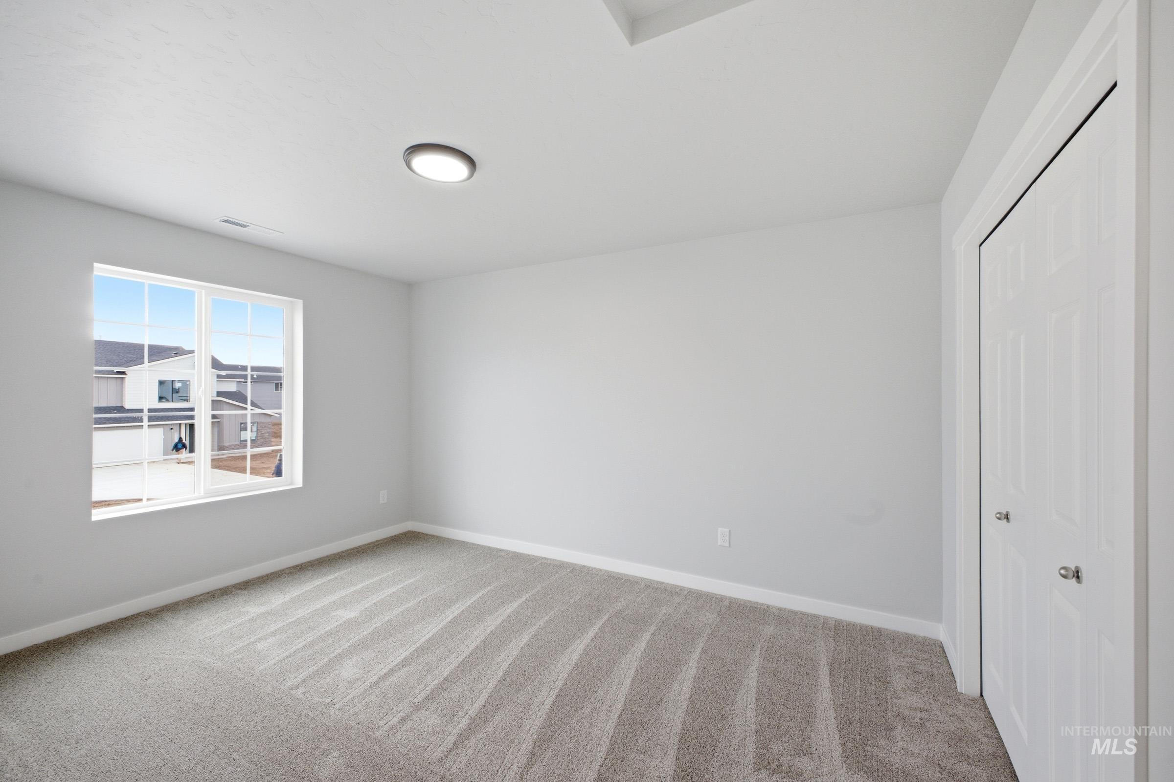 13702 Inman Court Caldwell, ID 83607 - Photo 17 of 23 Unfurnished bedroom with light carpet and a closet