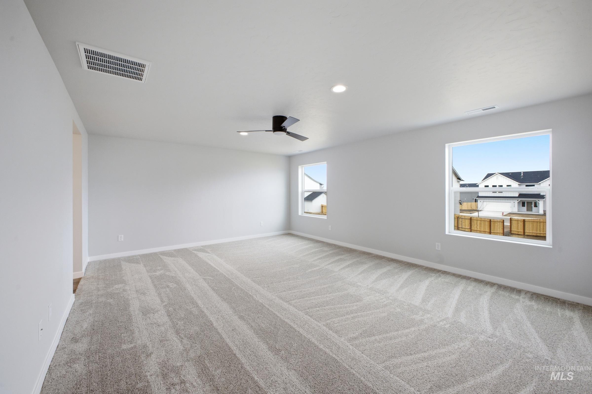 13702 Inman Court Caldwell, ID 83607 - Photo 20 of 23 Unfurnished room with light carpet, ceiling fan, and recessed lighting