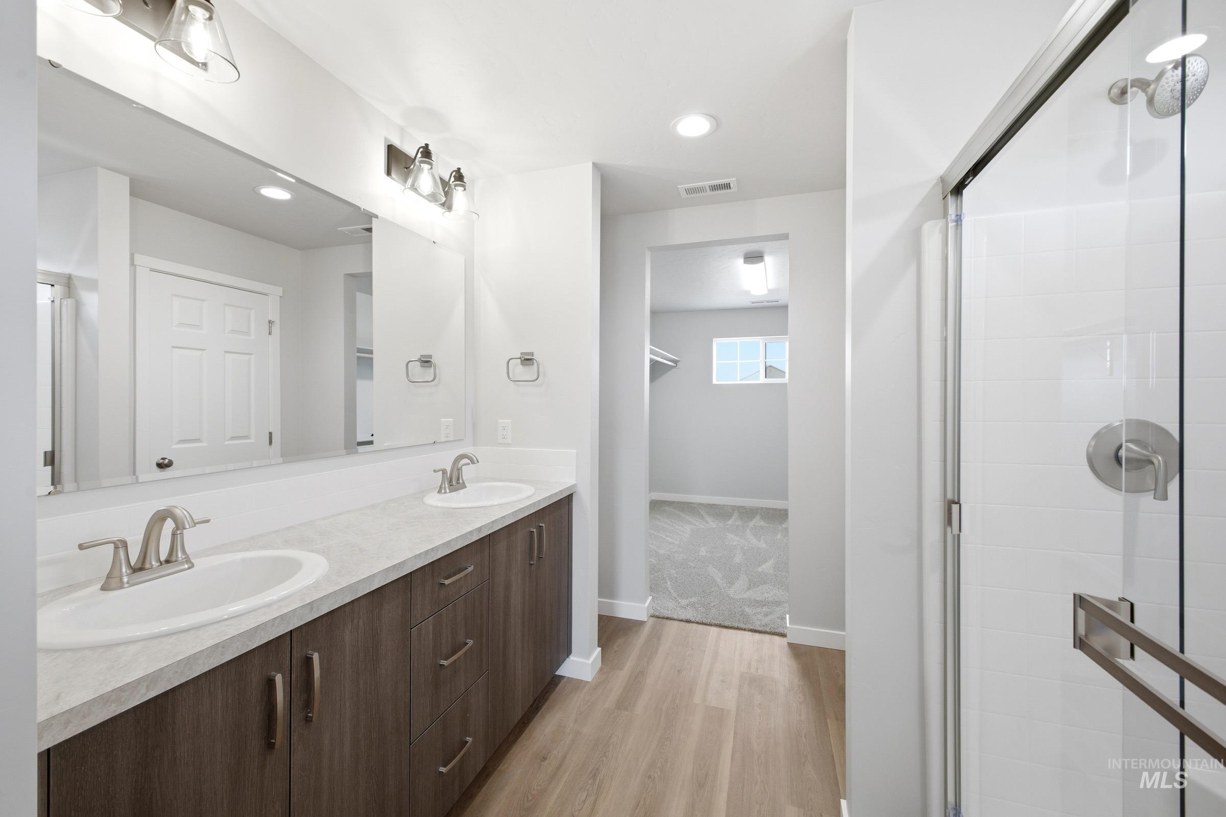 13702 Inman Court Caldwell, ID 83607 - Photo 22 of 23 Bathroom with double vanity, light wood finished floors, a stall shower, and recessed lighting