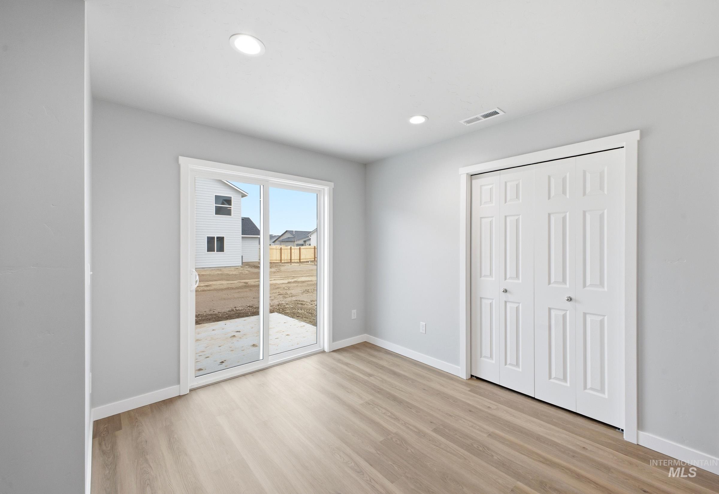 13702 Inman Court Caldwell, ID 83607 - Photo 6 of 23 Unfurnished bedroom with access to exterior, light wood-type flooring, a closet, and recessed lighting