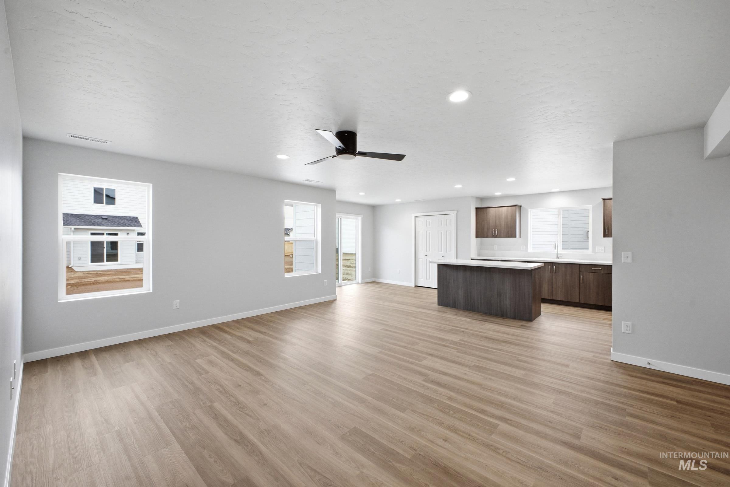 13702 Inman Court Caldwell, ID 83607 - Photo 9 of 23 Unfurnished living room featuring a ceiling fan, light wood finished floors, and recessed lighting