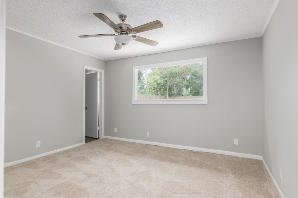 92 Sparrow Way Beaumont, TX 77707 - Photo 16 of 19 an empty room with wooden floor chandelier fan and windows