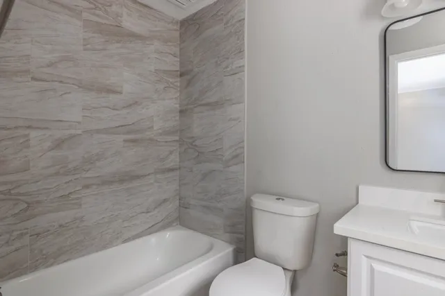 a bathroom with a toilet sink and mirror