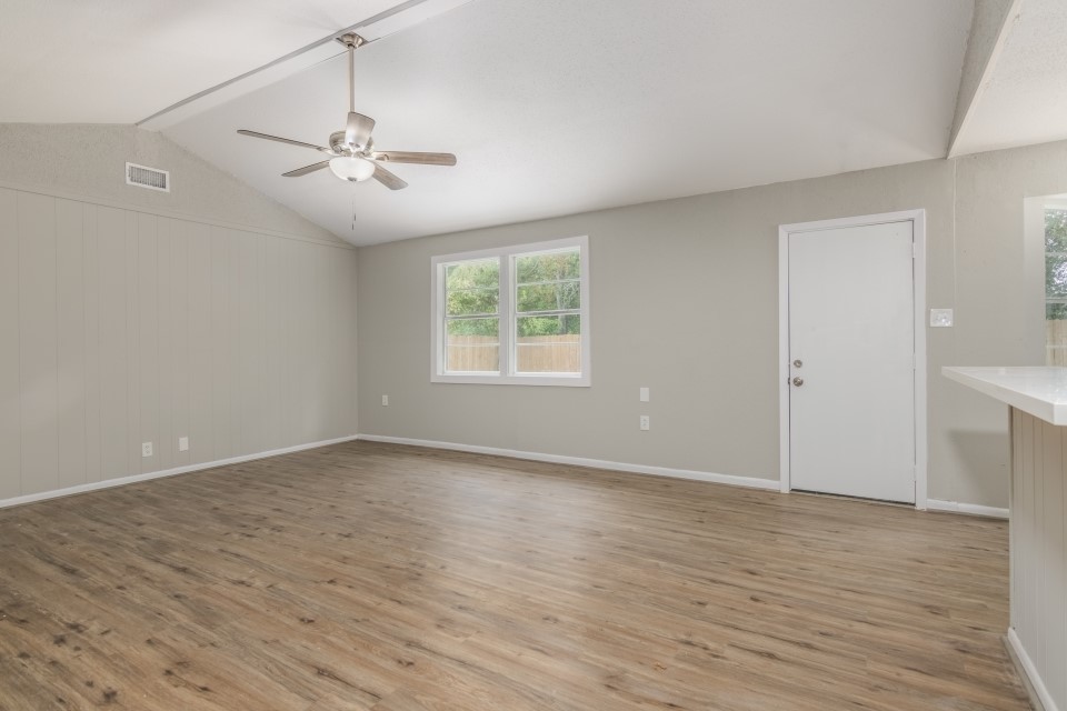 92 Sparrow Way Beaumont, TX 77707 - Photo 6 of 19 an empty room with wooden floor chandelier fan and windows