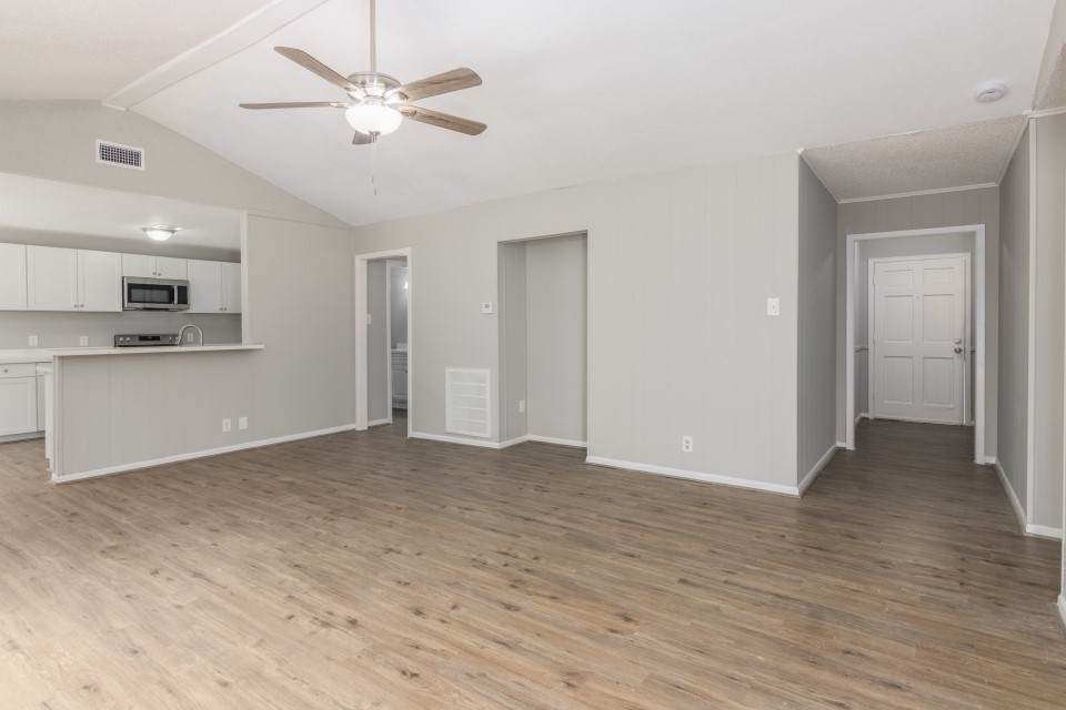 92 Sparrow Way Beaumont, TX 77707 - Photo 7 of 19 a view of empty room with wooden floor and kitchen view