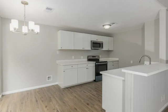 a kitchen with a sink a microwave and cabinets