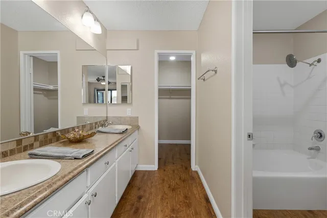 a bathroom with a granite countertop sink a mirror and a bathtub