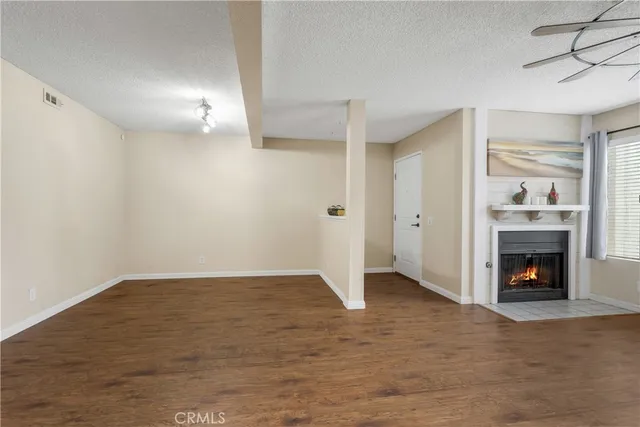 an empty room with fireplace and wooden floor