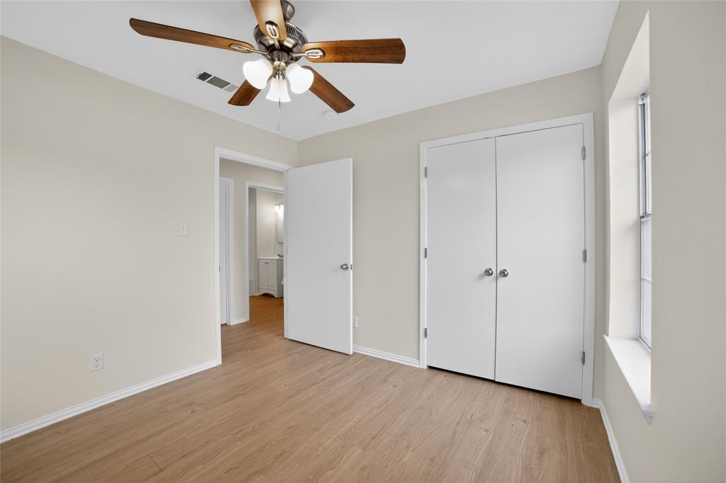 808 Park Street Commerce, TX 75428 - Photo 18 of 29 This room features wood-look flooring, a ceiling fan with light fixture, and a window providing natural light