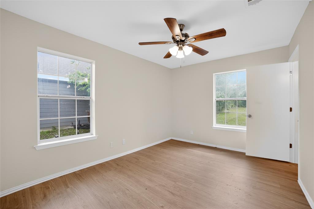 808 Park Street Commerce, TX 75428 - Photo 22 of 29 This room offers neutral walls, wood-look flooring, and a ceiling fan with light fixture