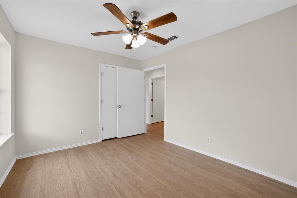 808 Park Street Commerce, TX 75428 - Photo 24 of 29 This room features light-colored walls, wood-look flooring, and a ceiling fan with integrated lighting