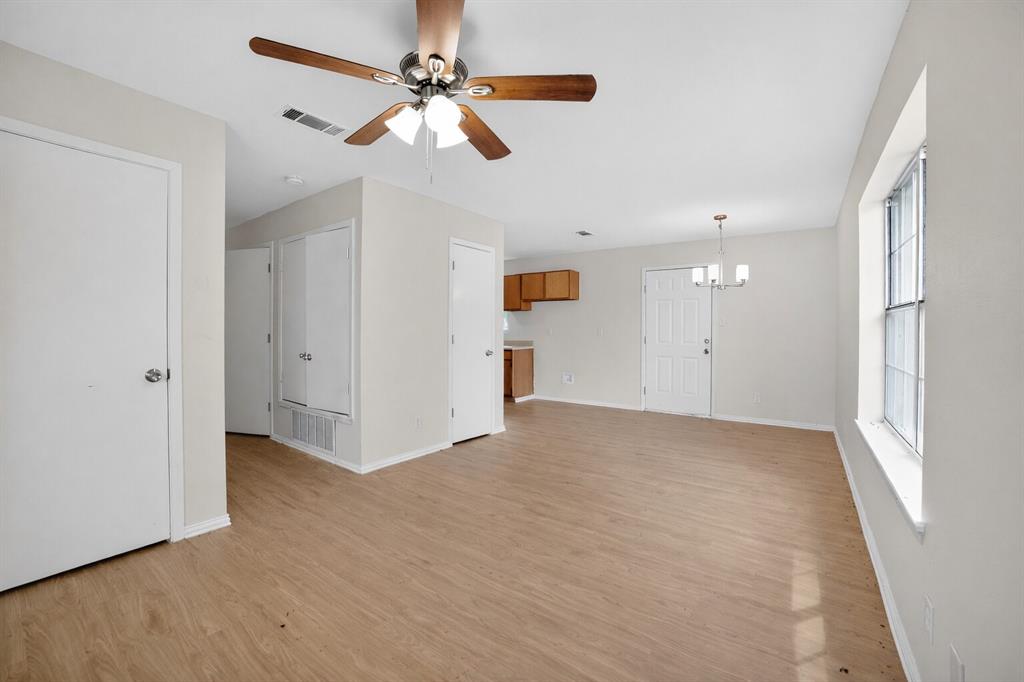 808 Park Street Commerce, TX 75428 - Photo 4 of 29 Open concept living area featuring light wood-look flooring and light-colored walls