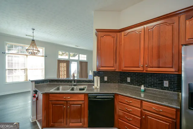 a kitchen with stainless steel appliances granite countertop wooden cabinets a sink and a granite counter tops