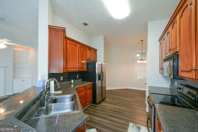 a view of a room with wooden floor and chandelier