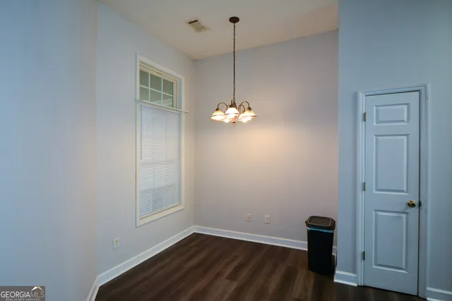 a view of a room with wooden floor and a window