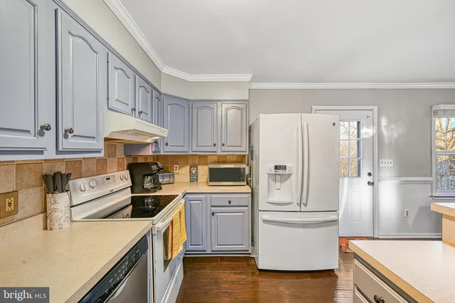 a kitchen with a refrigerator a stove top oven a sink and cabinets