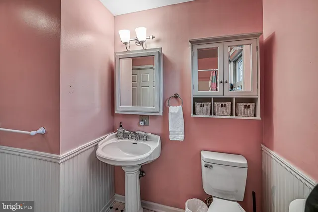 a bathroom with a toilet sink and mirror