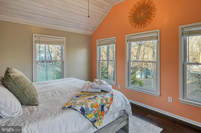 a bedroom with a bed mirror and window
