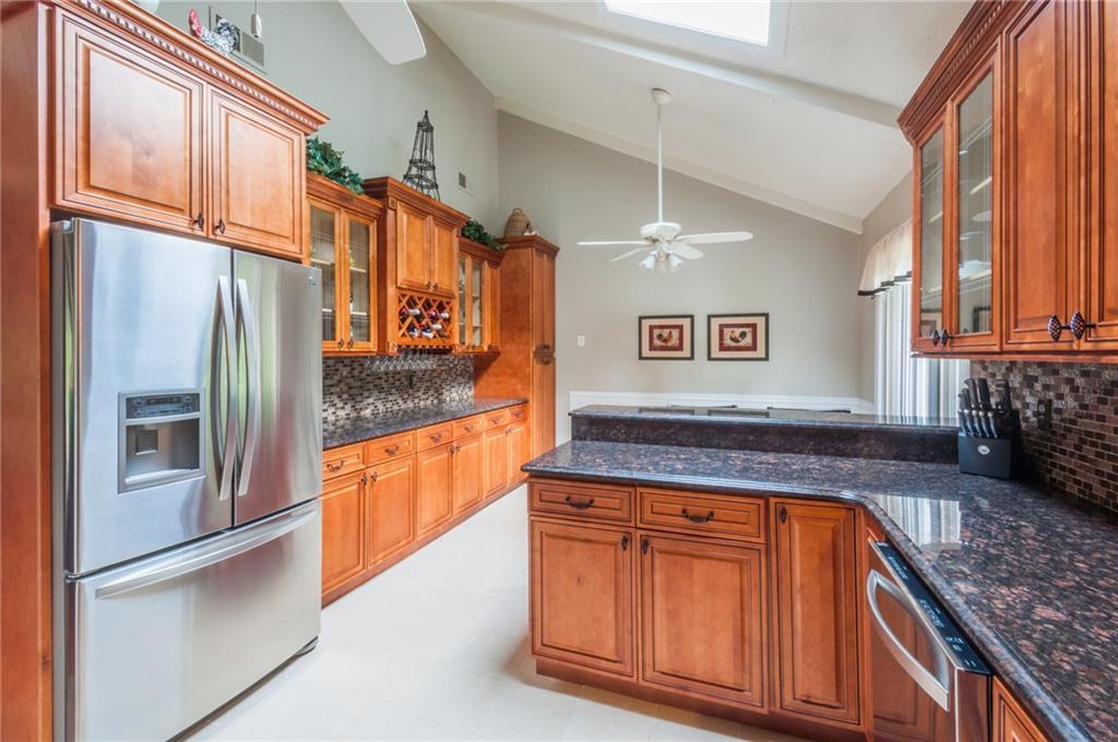 a kitchen with stainless steel appliances granite countertop a refrigerator a sink and dishwasher