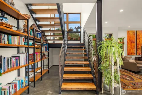 a room with lots of books and a potted plant
