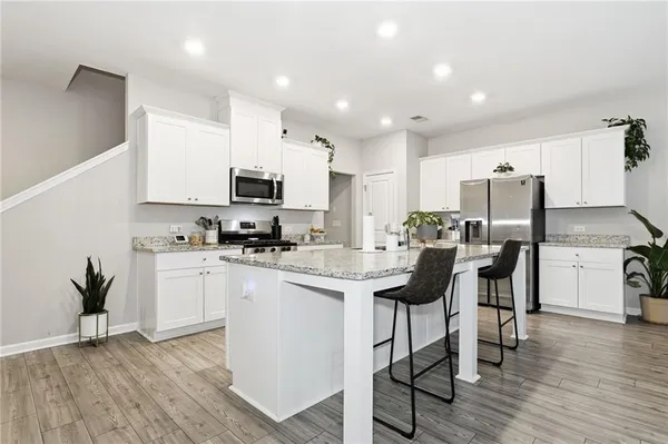 a kitchen with granite countertop a sink cabinets and wooden floor