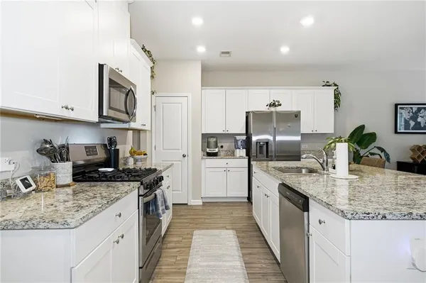 a kitchen with stainless steel appliances granite countertop a sink stove and refrigerator