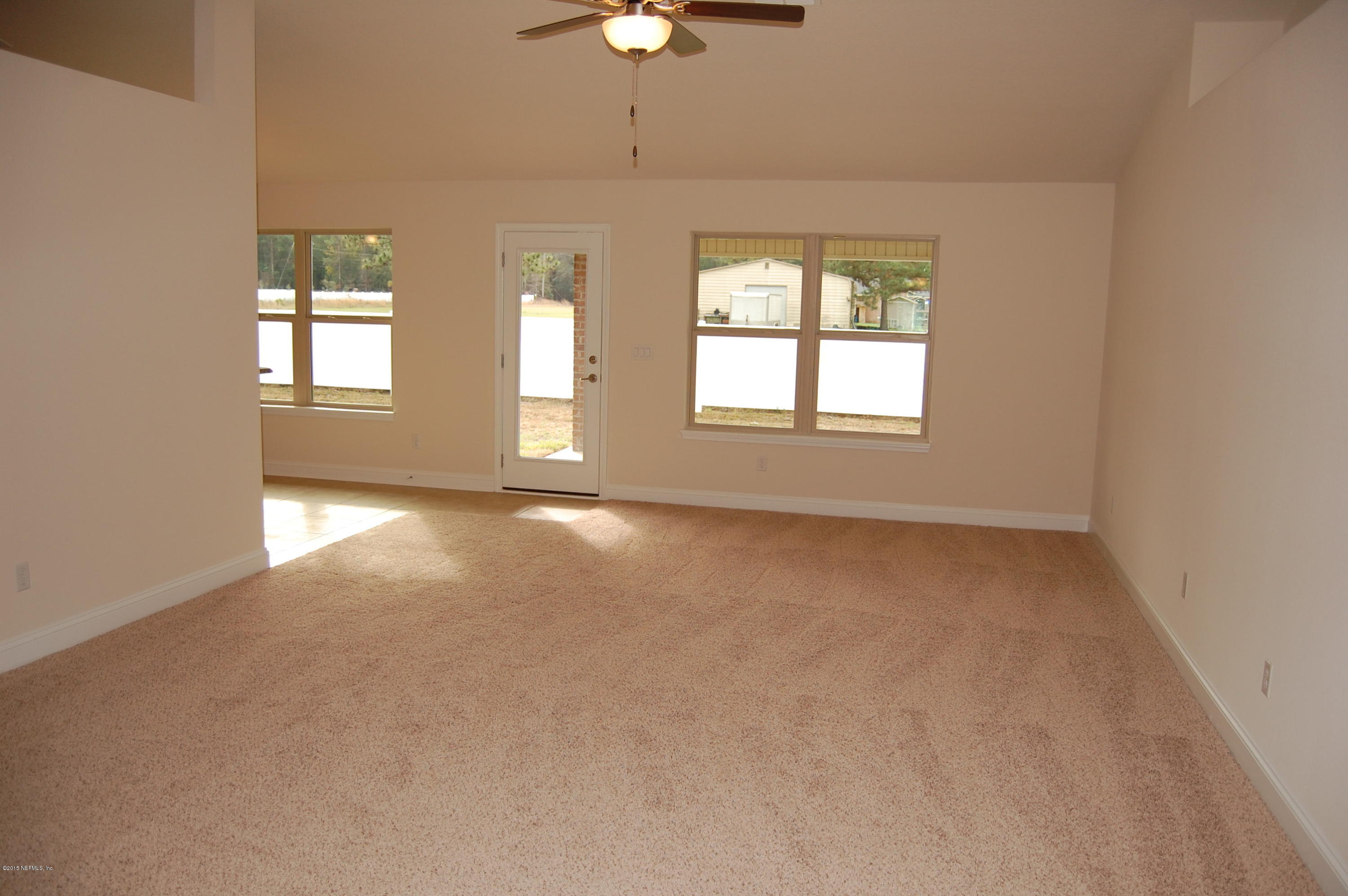 8000 Capeside Way Jacksonville, FL 32222 - Photo 11 of 32 an empty room with a windows and chandelier fan