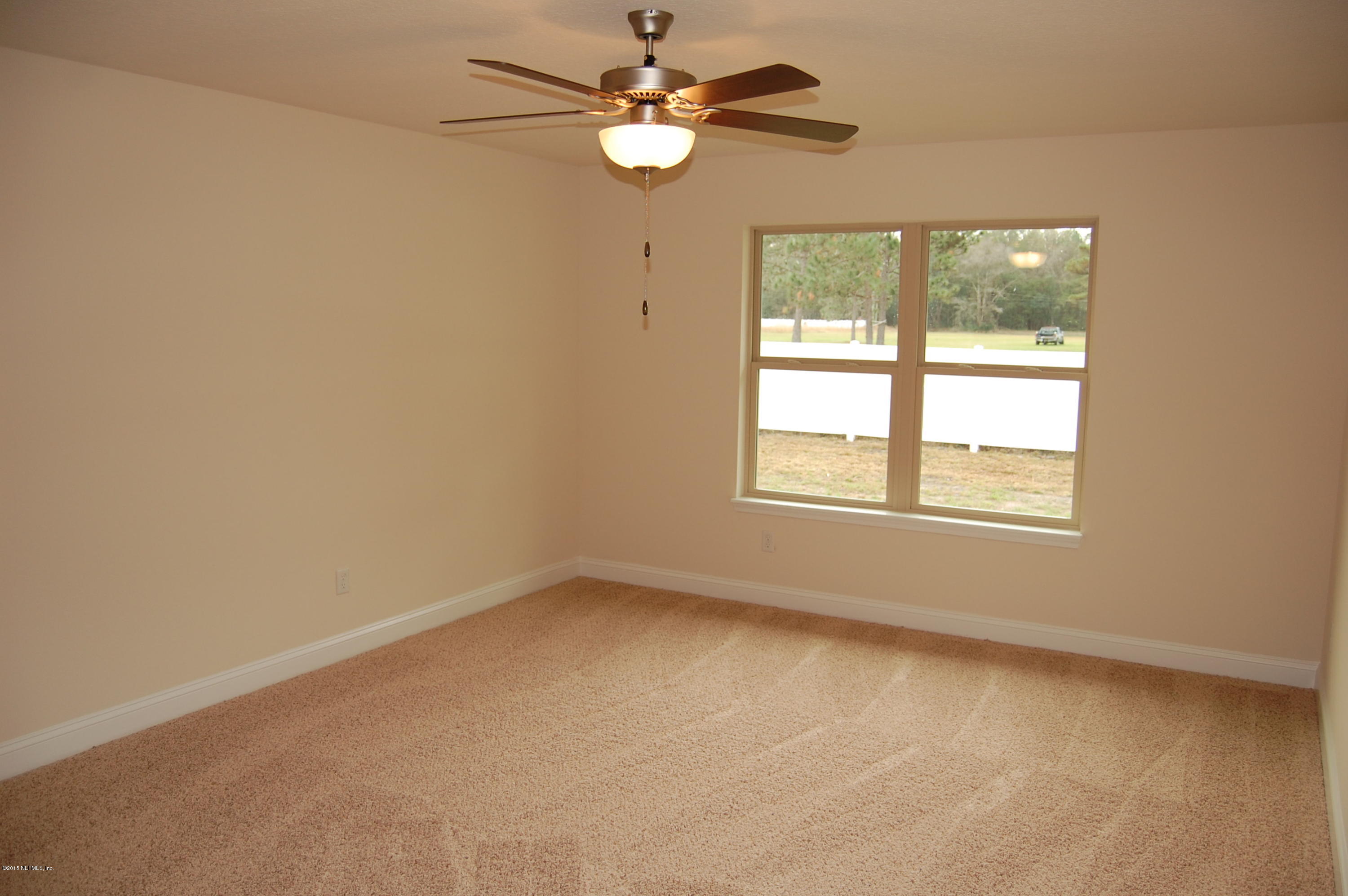 8000 Capeside Way Jacksonville, FL 32222 - Photo 18 of 32 an empty room with a window and a fan