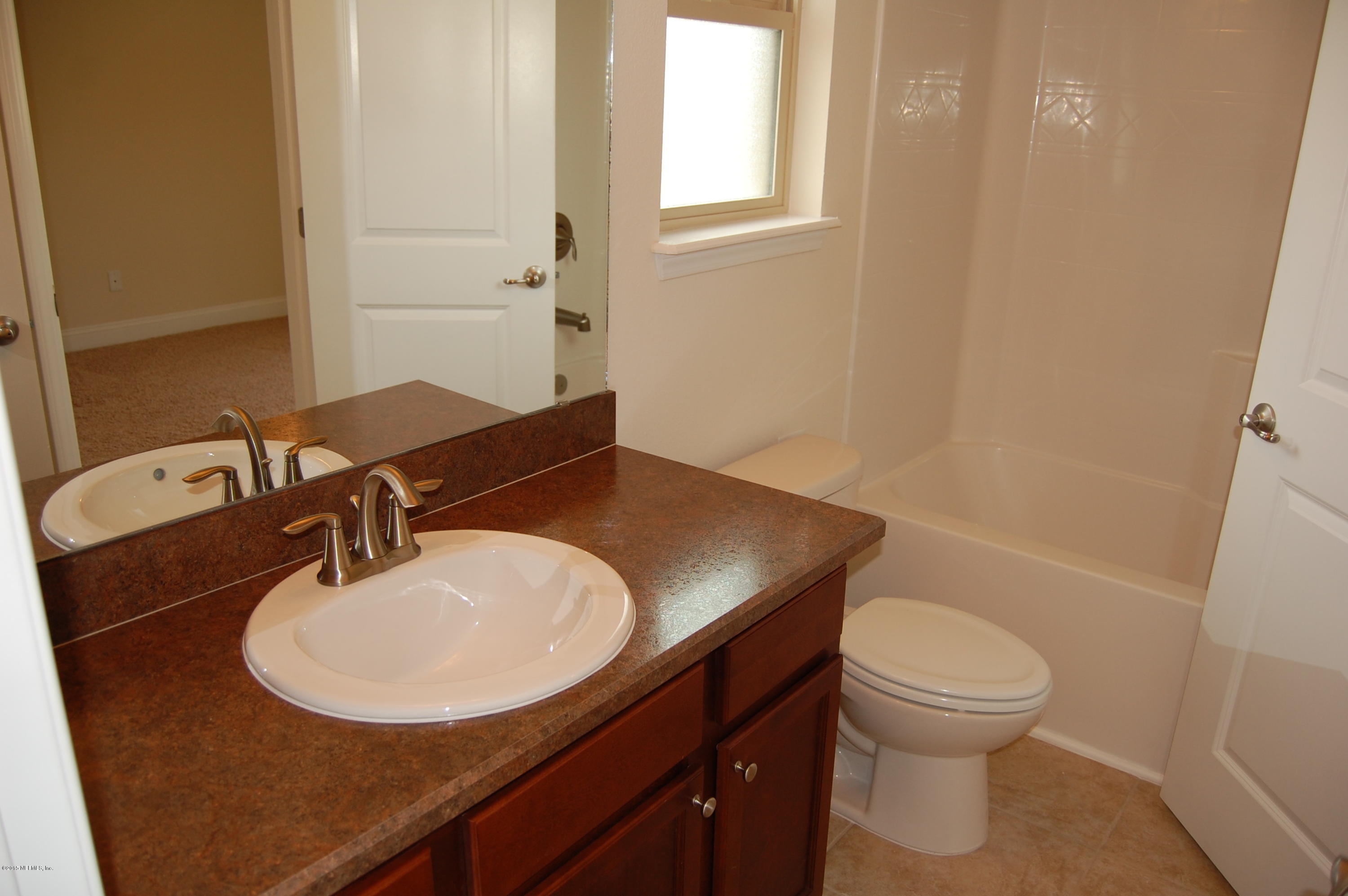 8000 Capeside Way Jacksonville, FL 32222 - Photo 30 of 32 a bathroom with a sink a toilet and a mirror