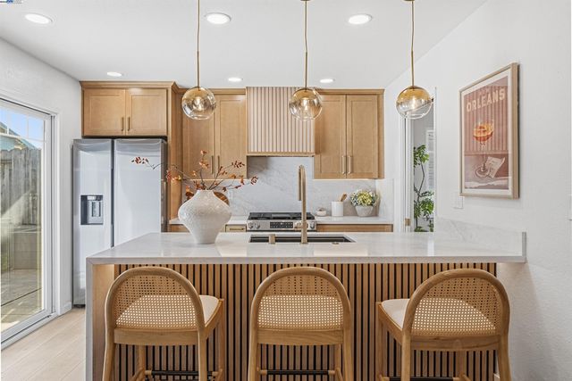 a kitchen with stainless steel appliances granite countertop a stove a sink and a refrigerator