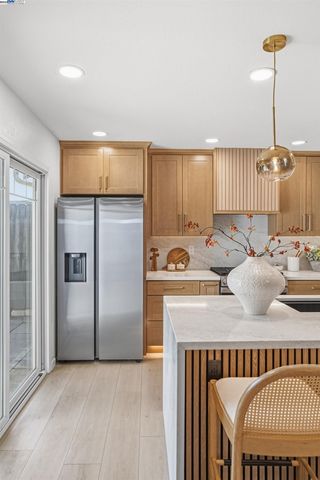 a kitchen with stainless steel appliances granite countertop a refrigerator a sink and a stove