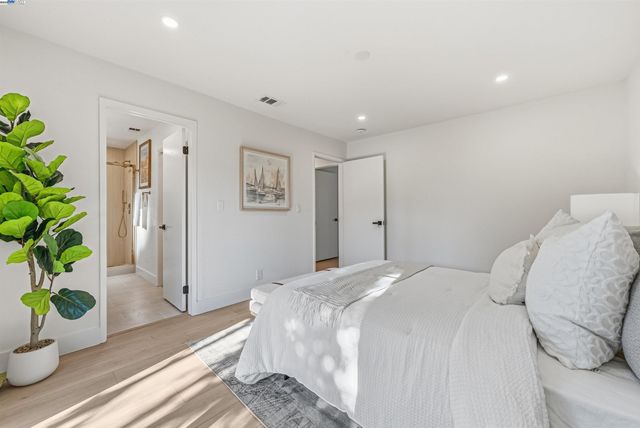 a bedroom with a bed and a potted plant