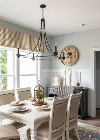 a dining room with furniture a chandelier and a large window