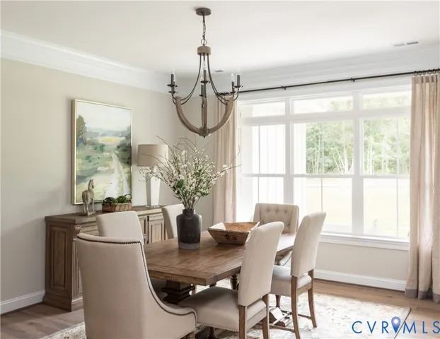 a dining room with furniture a chandelier and wooden floor