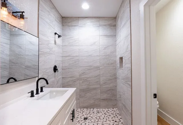 a bathroom with a sink a toilet and shower