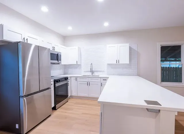 a kitchen with stainless steel appliances a refrigerator sink and stove