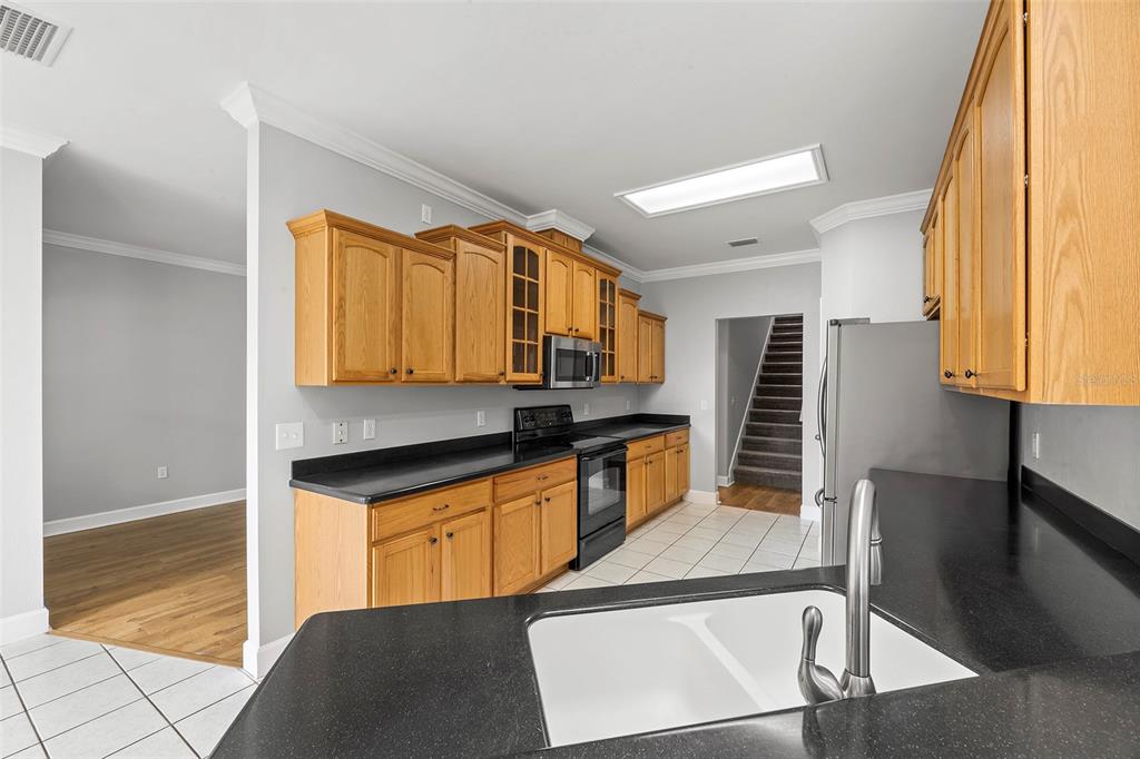 8376 Southwest 80th Place Gainesville, FL 32608 - Photo 12 of 37 a kitchen with granite countertop a stove a sink and a refrigerator