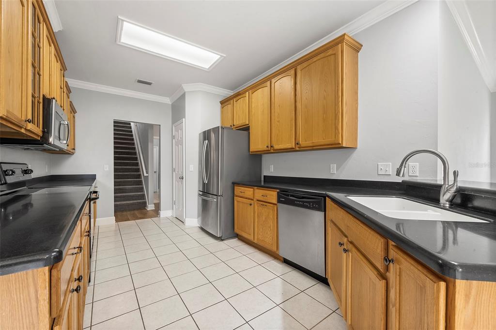 8376 Southwest 80th Place Gainesville, FL 32608 - Photo 13 of 37 a kitchen with stainless steel appliances granite countertop a sink stove and refrigerator