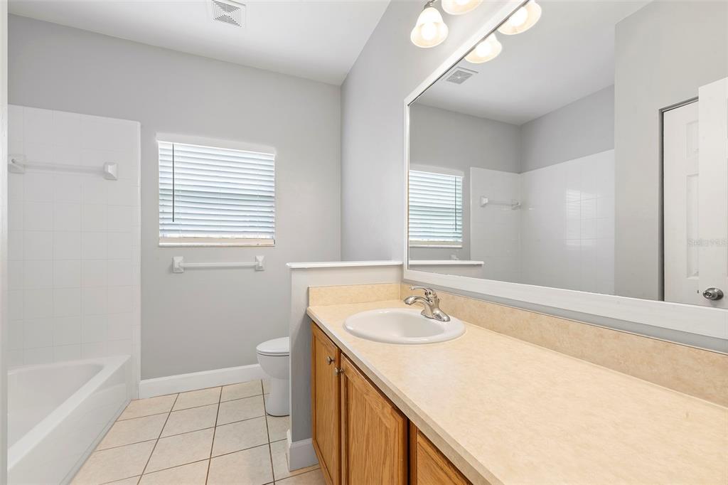 8376 Southwest 80th Place Gainesville, FL 32608 - Photo 22 of 37 a bathroom with a sink a vanity and a bathtub