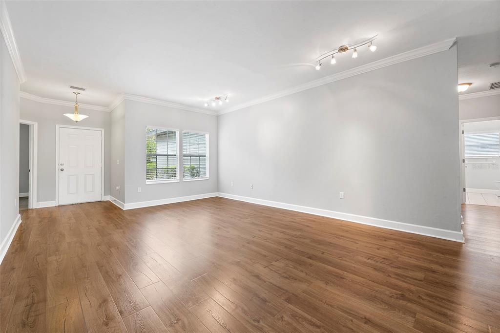 8376 Southwest 80th Place Gainesville, FL 32608 - Photo 7 of 37 a view of an empty room with wooden floor and a window