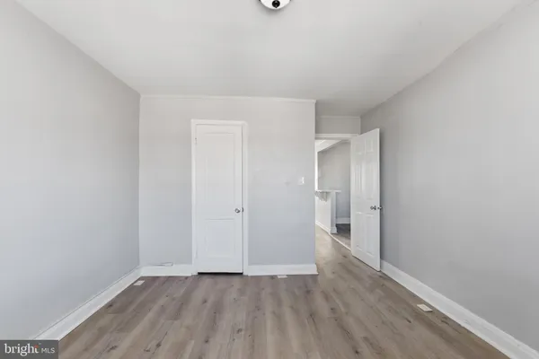 a view of an empty room with window and a ceiling fan with wooden floor