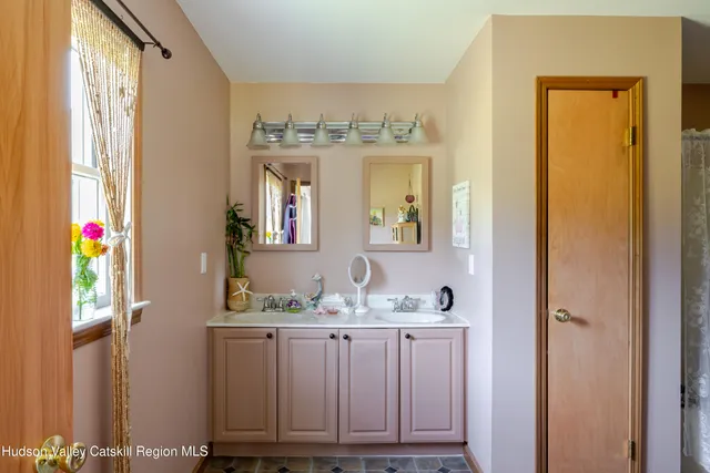 a bathroom with a sink a mirror and a window